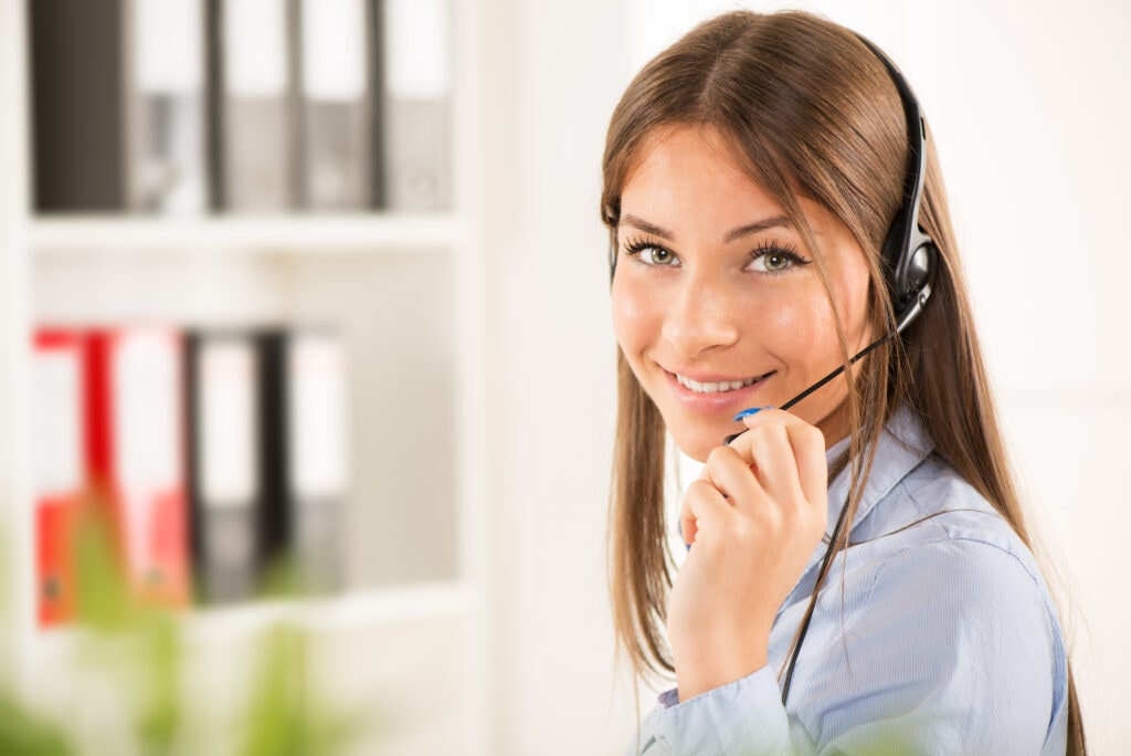 Medical Virtual Receptionist From Ruby Receptionist, Confidently Handling A Call At The Call Center Workstation.