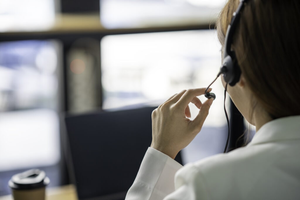 Friendly Female Helpline Operator From Ruby Receptionist, Wearing Headphones, Representing Medical Virtual Receptionist Services.