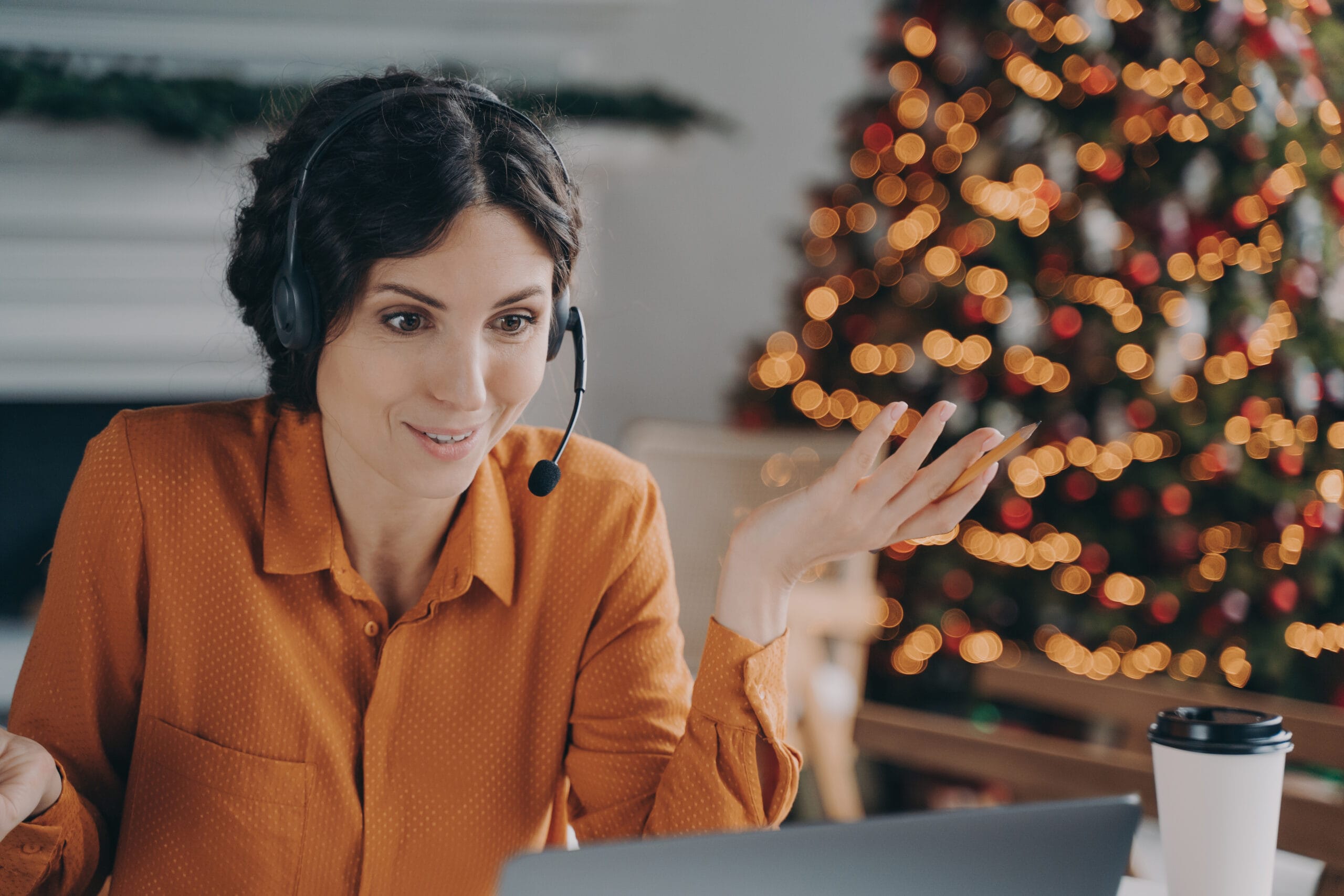 Callcenter Female Consultant In Headset Talking With Customer While Working During Christmas Holidays